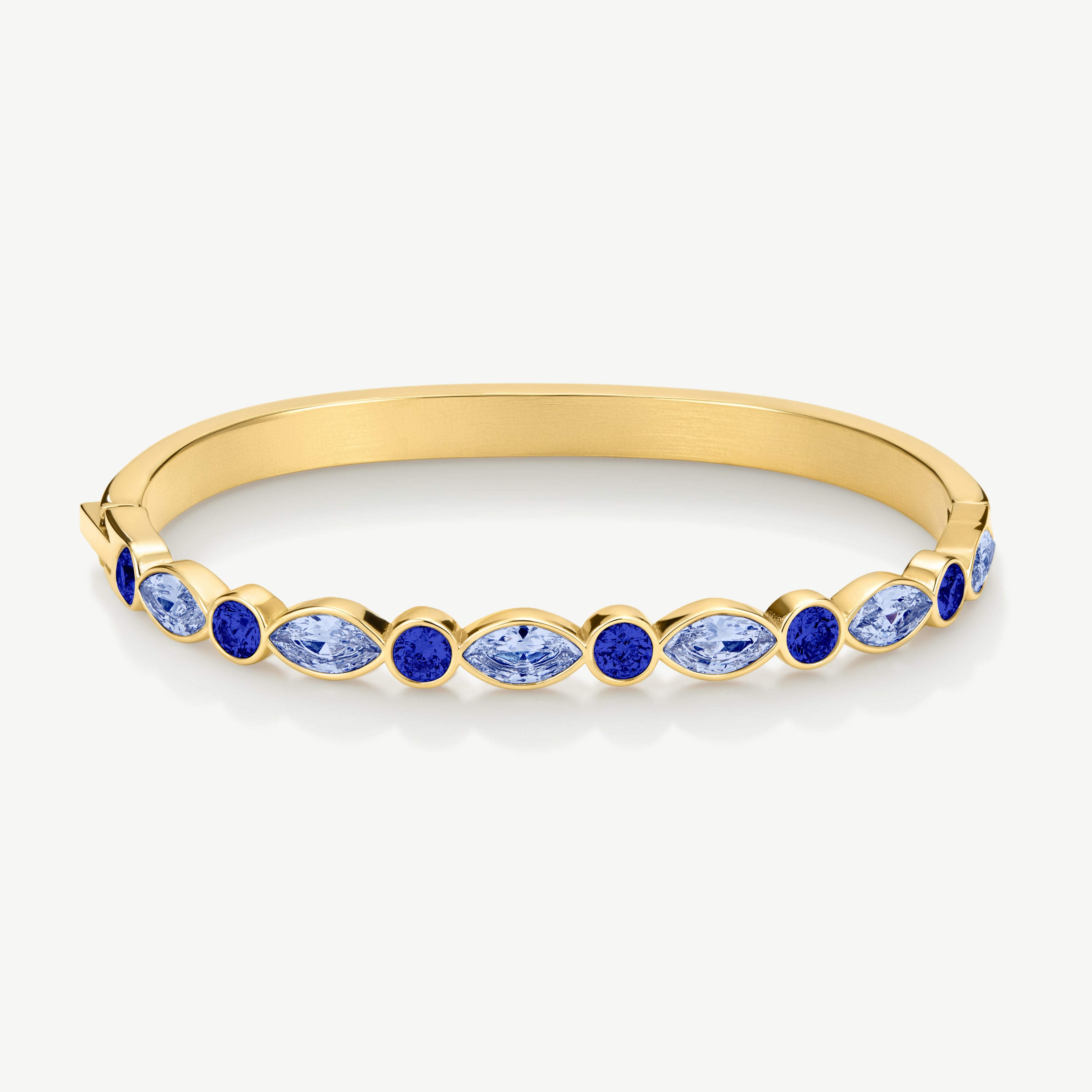 A gold bangle bracelet featuring a row of marquise-cut and round blue gemstones, displayed on a clean white background.