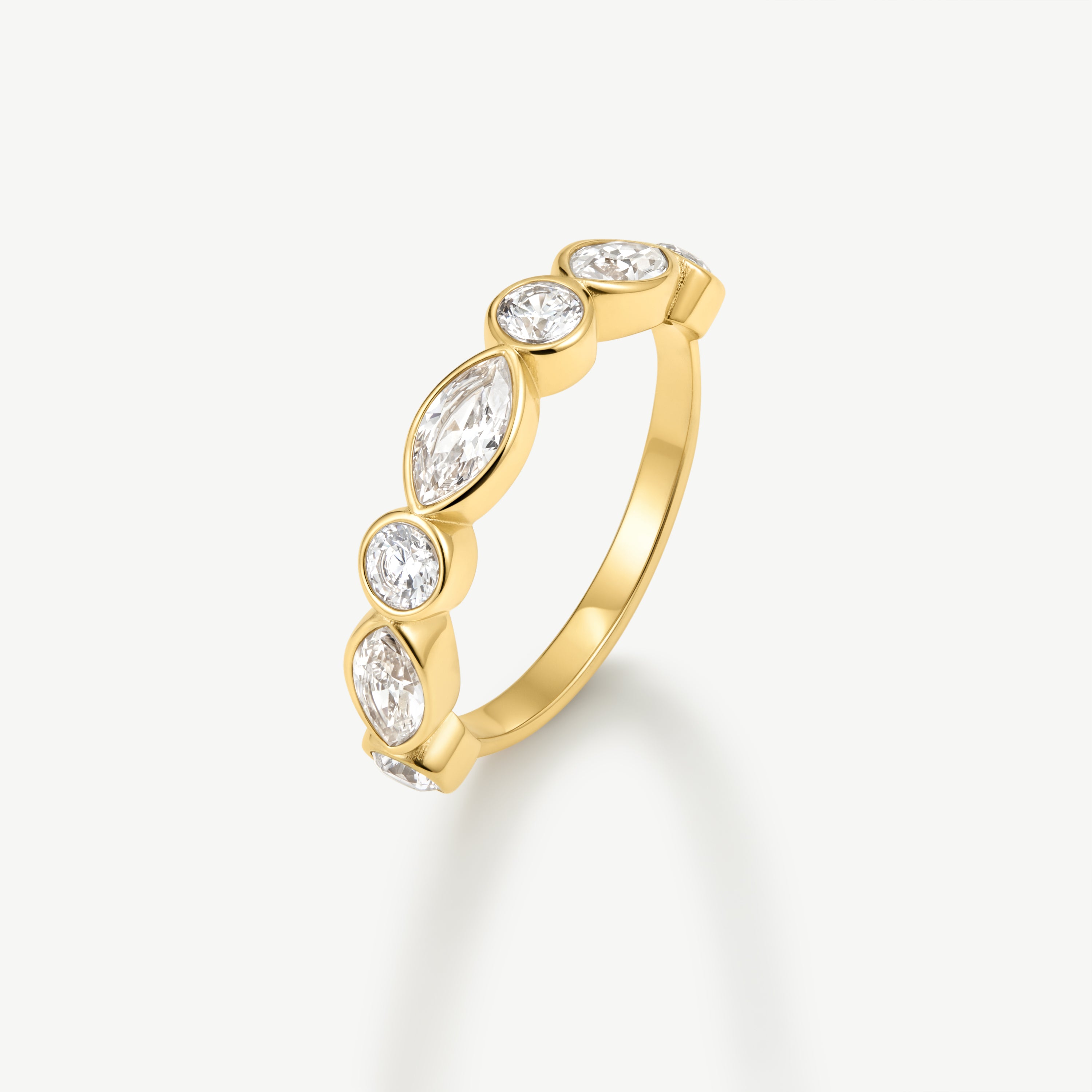 A yellow gold ring featuring five marquise-cut and round brilliant-cut clear gemstones set in a row, shown on a clean off-white background.