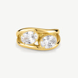 A yellow gold ring featuring two large, round-cut clear gemstones in a split setting, shown on a light gray background.