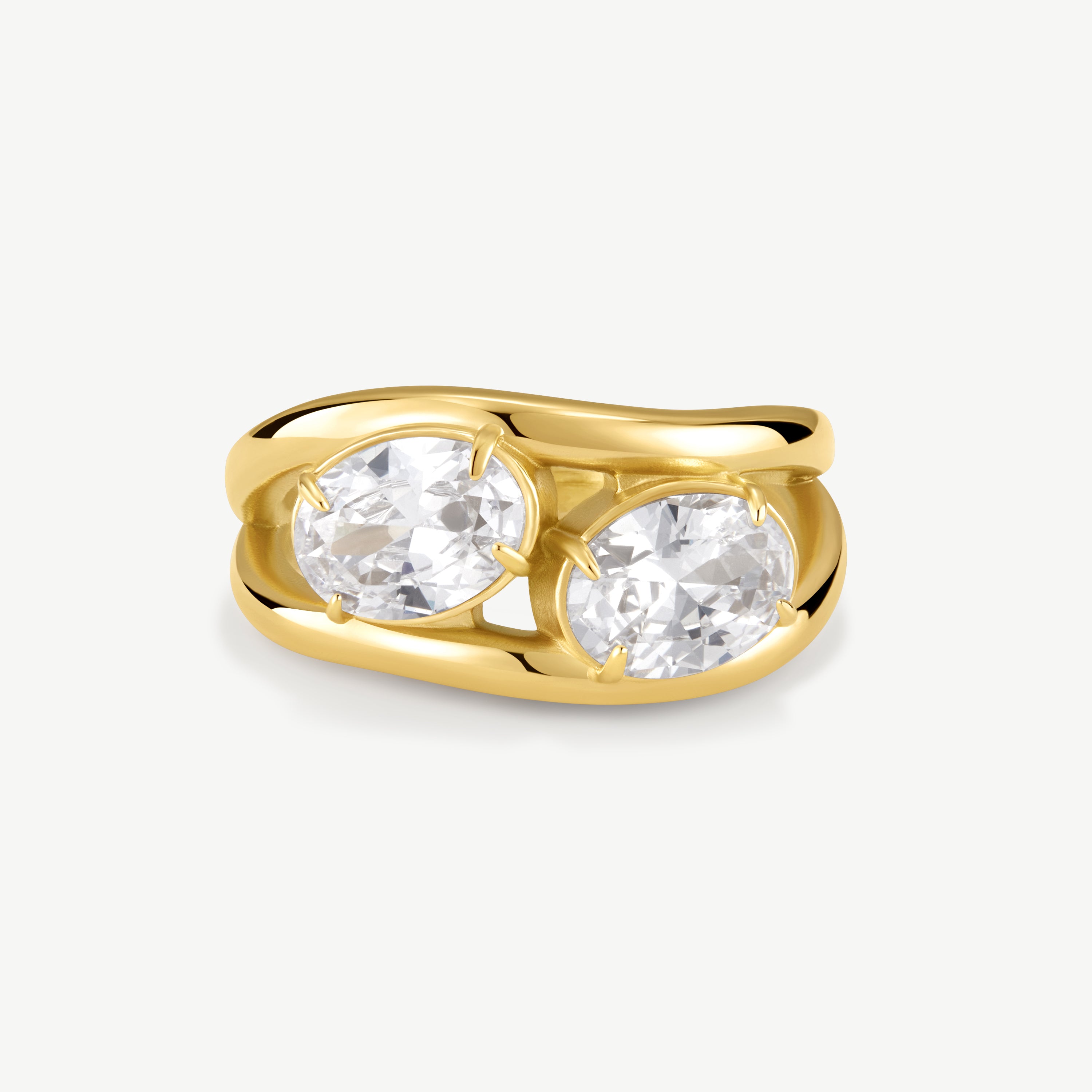 A yellow gold ring featuring two large, round-cut clear gemstones in a split setting, shown on a light gray background.